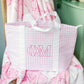 Pink gingham tote bag with Phi Mu Greek letters an white handles on a pink blanket
