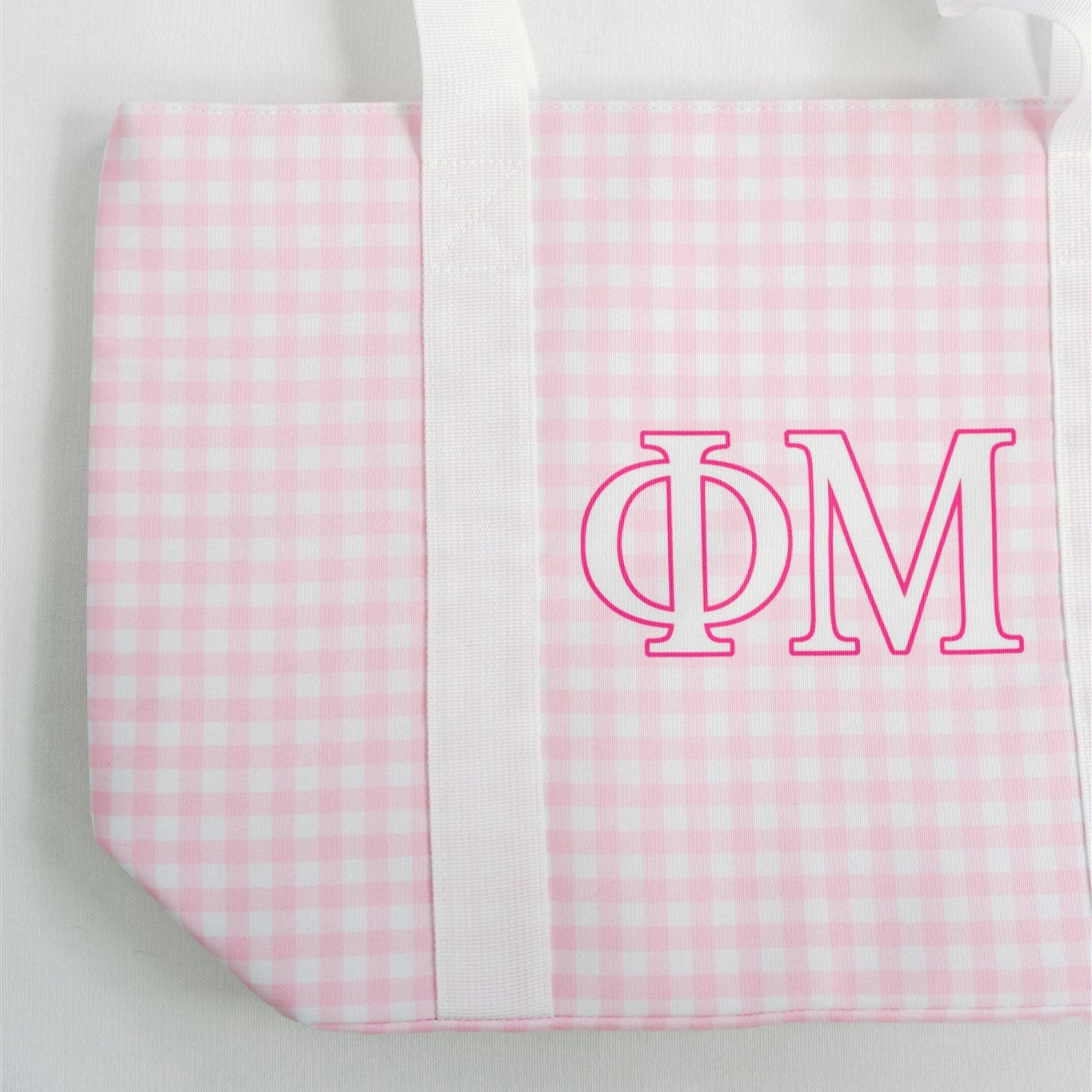 Pink and white checkered bag with 'Phi Mu' Greek letters and white straps.