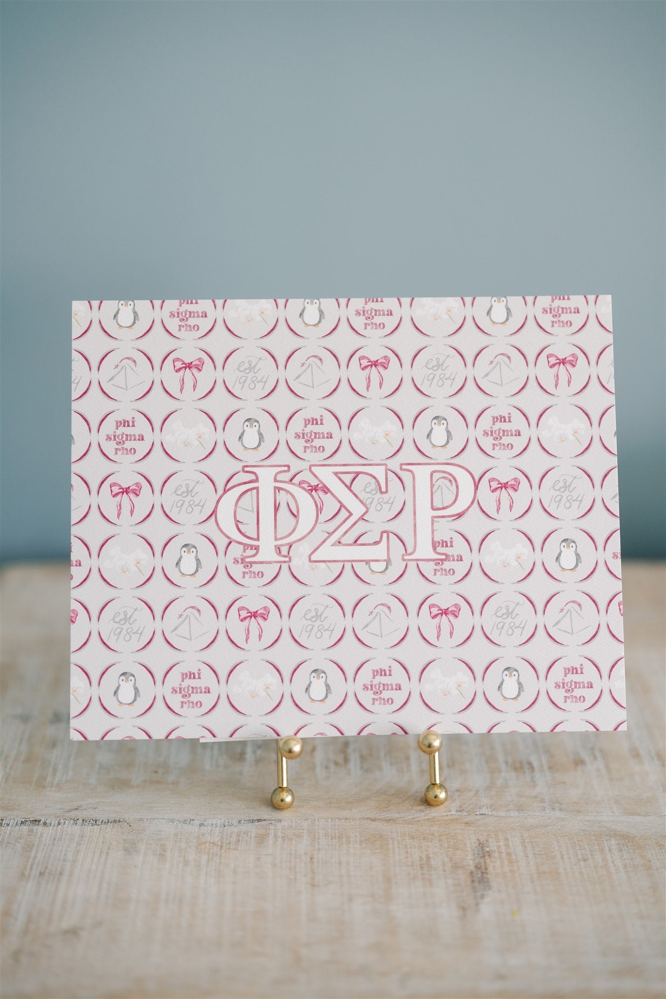 Art print with Phi Sigma Rho Greek letters symbols on a stand against a gray background