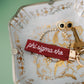 Decorative dish with jewelry and a red 'phi sigma rho' embroidered keychain.