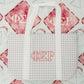 White and gray checkered tote bag with Phi Sigma Rho Greek letters on a red and gray blanket