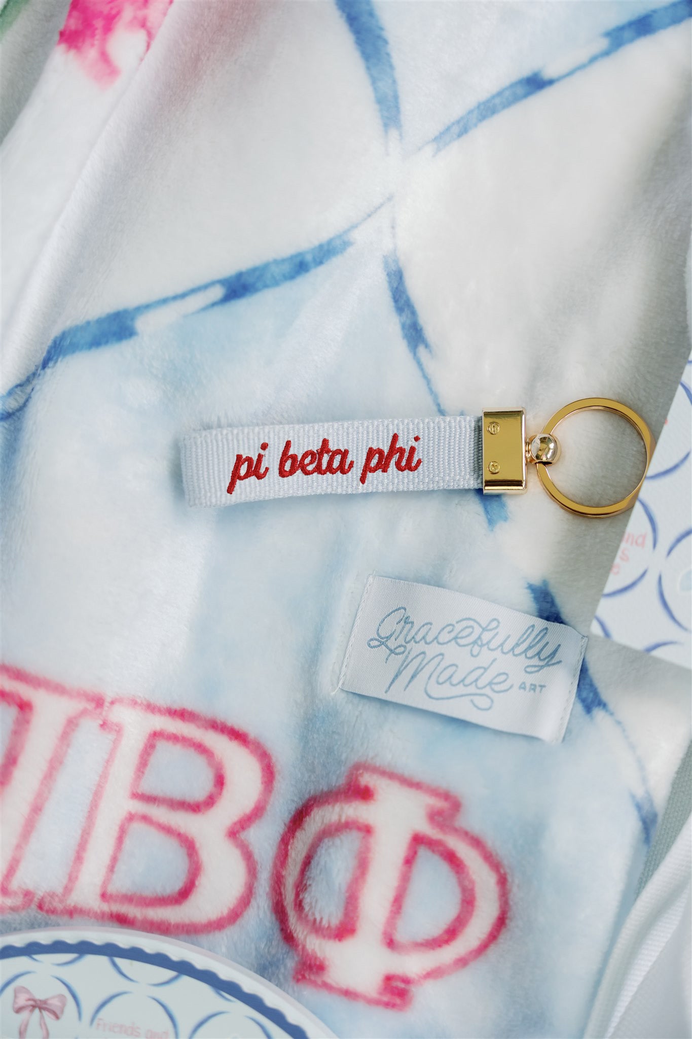 Keychain with 'pi beta phi' embroidery on the Phi Beta Phi fleece blanket.