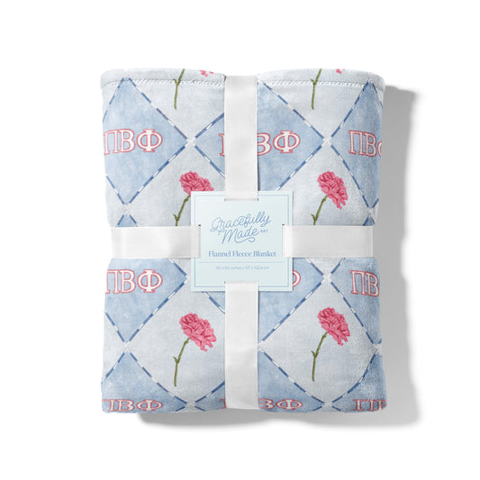 Folded blanket with Pi Beta Phi floral and geometric pattern.