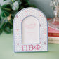 Decorative photo frame with circular patterns and Pi Beta Phi Greek letters on a green surface.