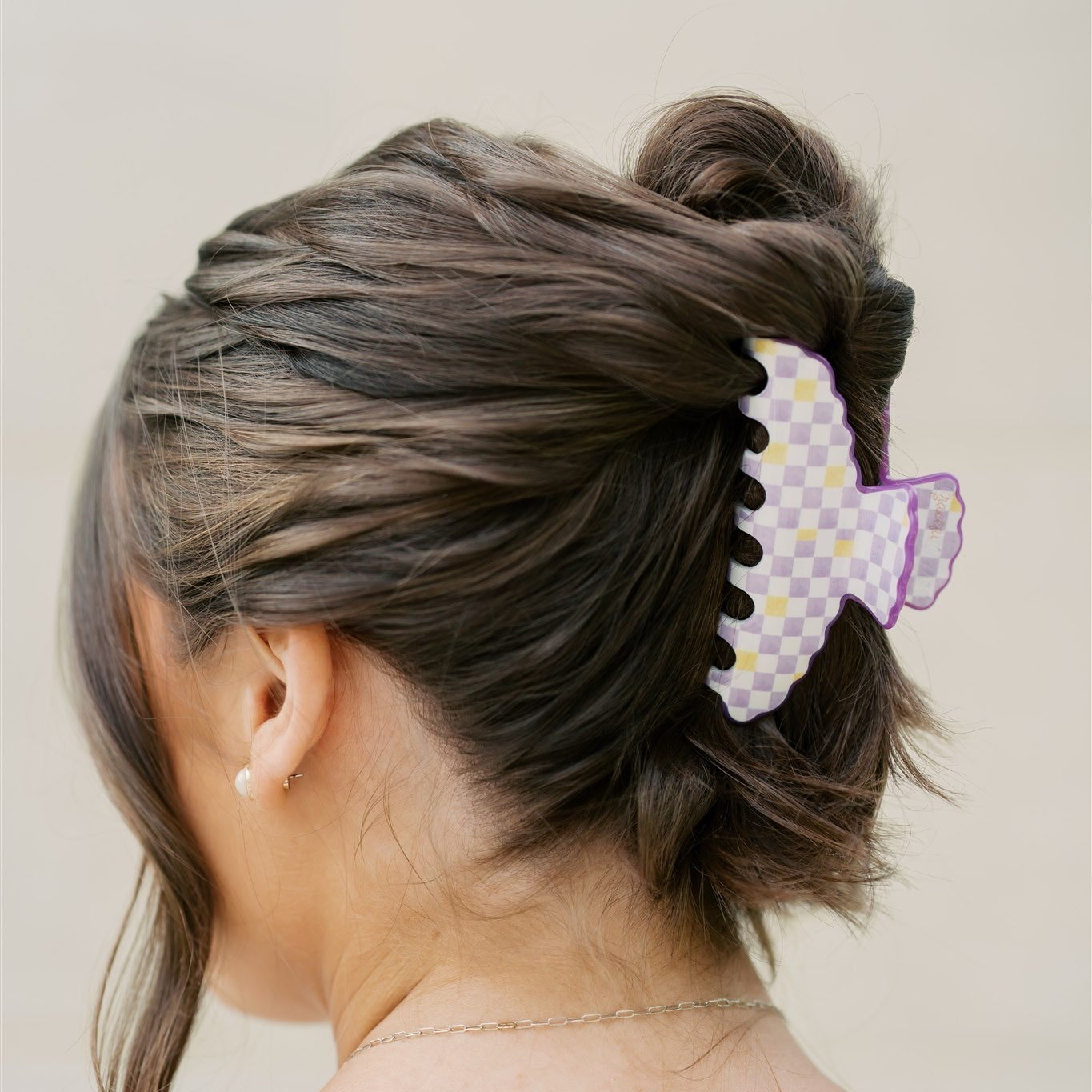 Woman with a stylish hair bun adorned with a decorative purple and yellow hair clip