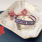 White, navy, and red woven bracelet with "Samford Bulldogs" written on it.