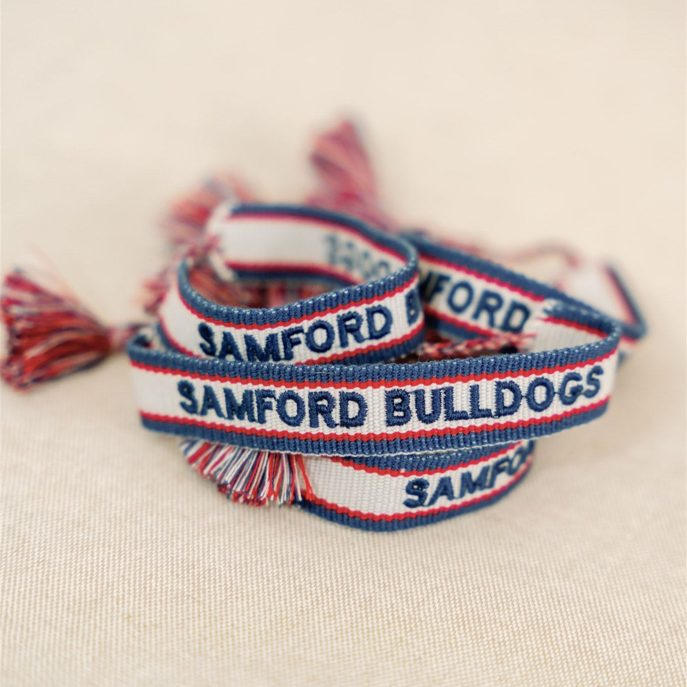 White, navy, and red woven bracelet with "Samford Bulldogs" written on it.