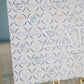 Decorative art print with Sigma Delta Tau Greek letters and pattern on a stand against a blue background