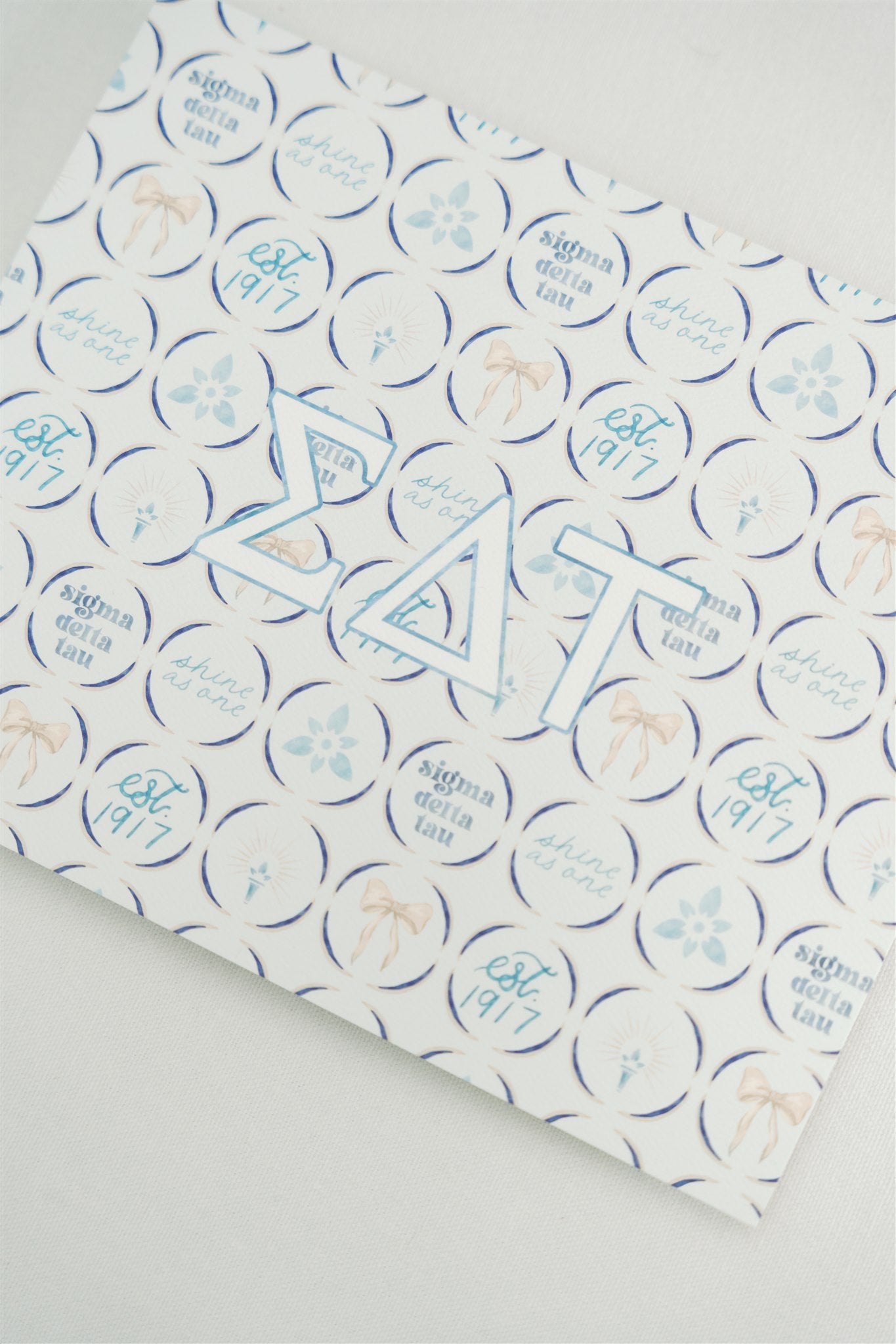Art print with Sigma Delta Tau Greek letters on a blue patterned background.