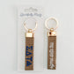 Front and back of the Sigma Delta Tau embroidered keychain with Gracefully Made Art branded packaging. 
