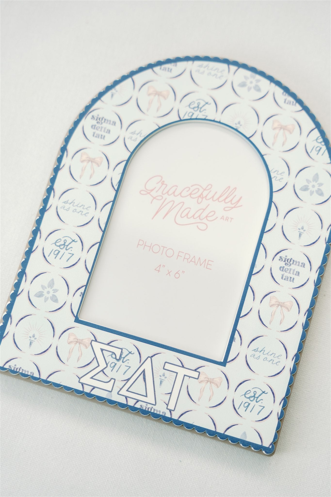 Decorative photo frame with circular patterns and Sigma Delta Tau Greek letters on a white background