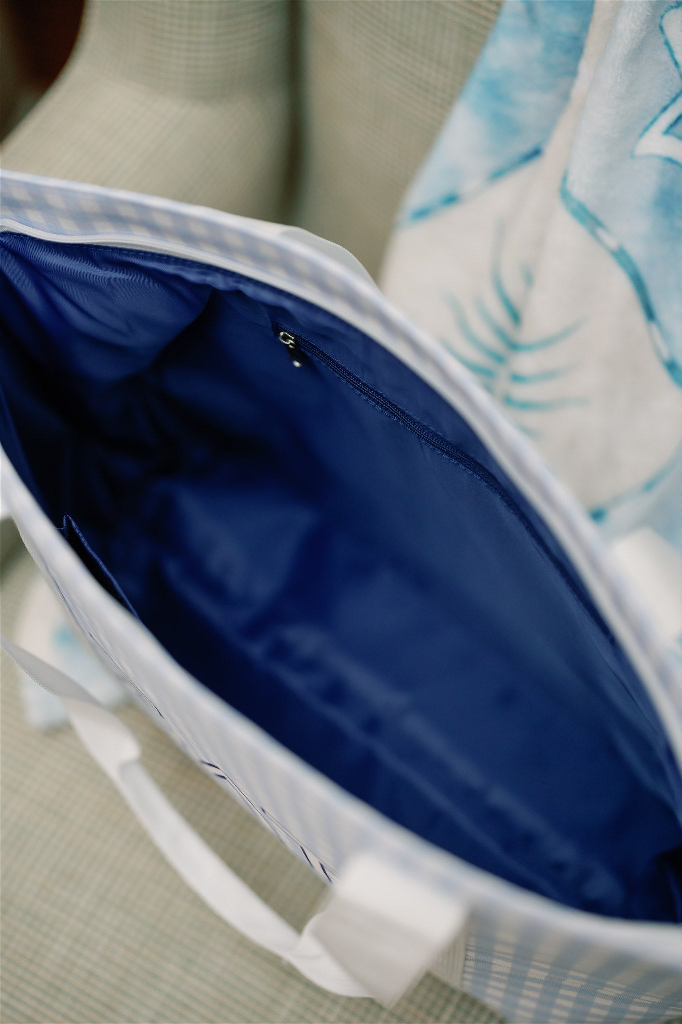 Close up of the Sigma Delta Tau tote bag's deep blue interior liner and zipper pocket.