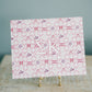 Decorative art print with 'Sigma Kappa' design and Greek letters on a stand against a blue background