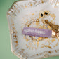 Decorative jewelry dish with 'sigma kappa' keychain and other accessories on a green background