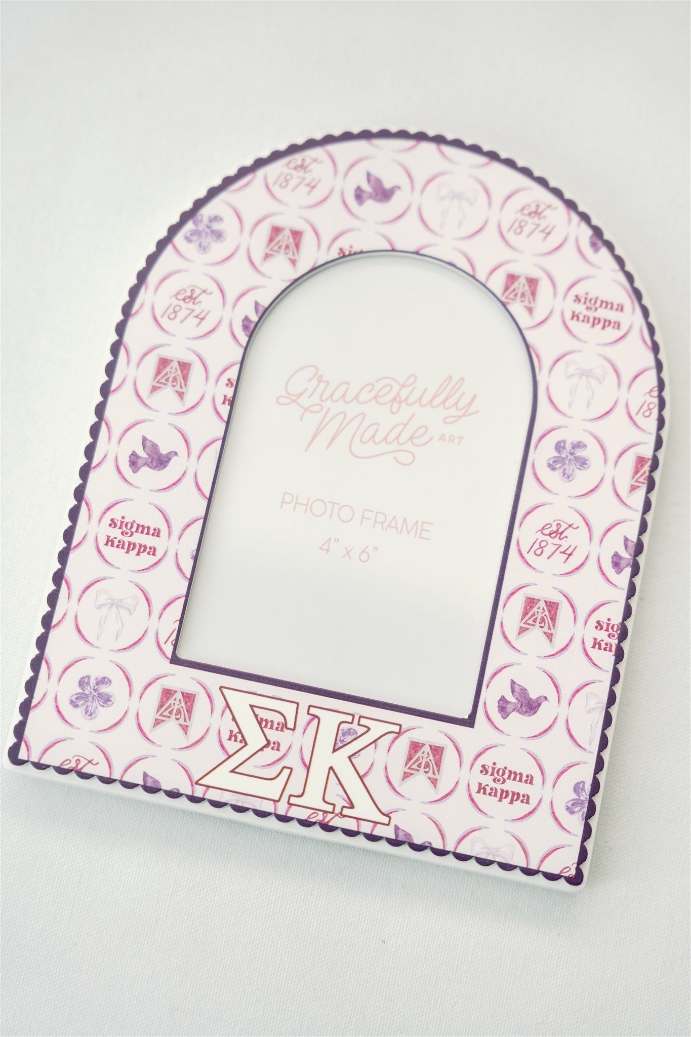 Decorative frame with Sigma Kappa Greek letters and pattern on a white background.