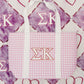 Purple gingham tote bag with white handles and Sigma Kappa Greek letters on a patterned background