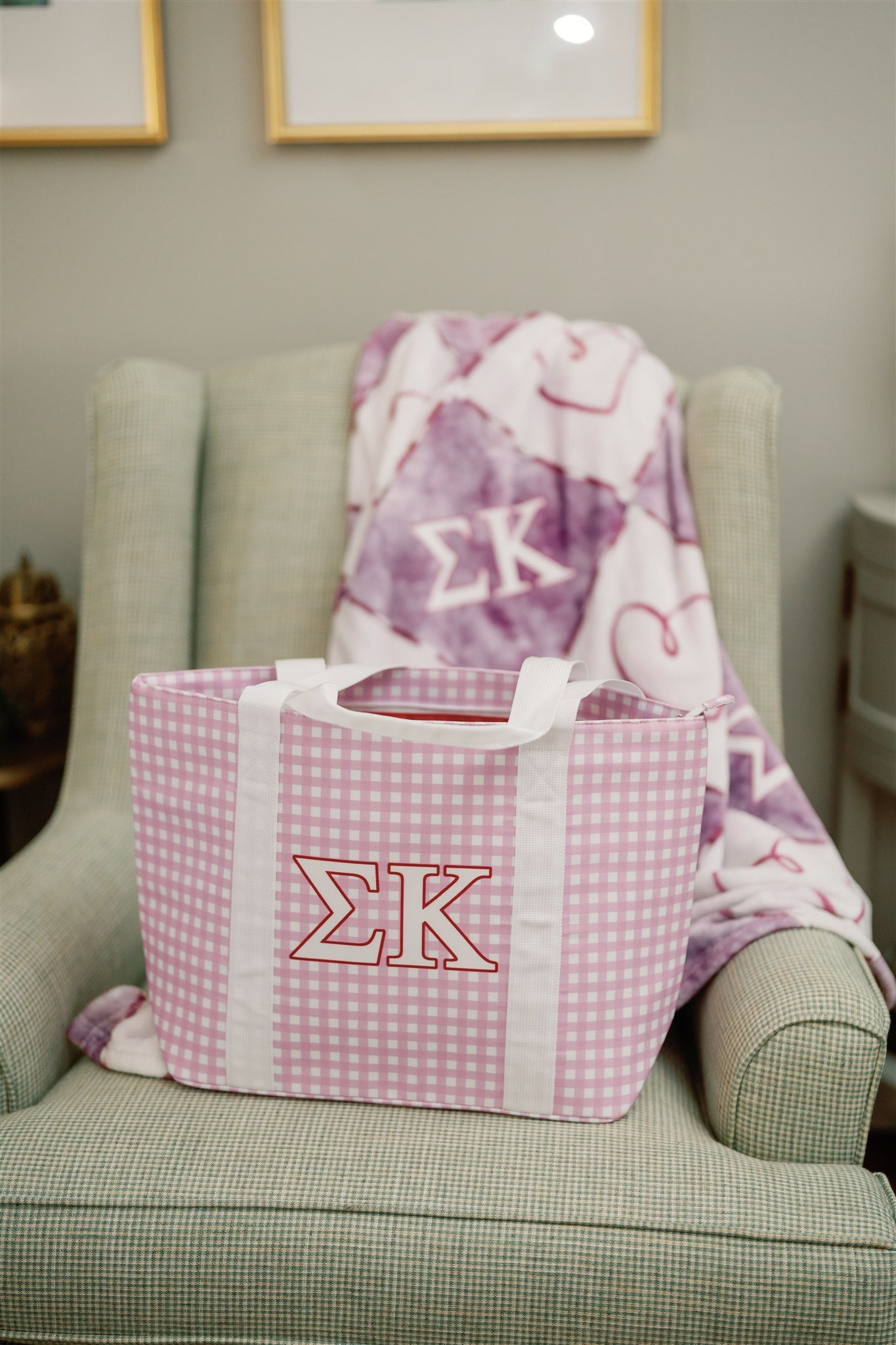 Purple gingham bag with Sigma Kappa Greek letters on a chair with a matching blanket.
