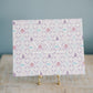 Decorative art print with geometric pattern  and Tri Sigma Greek letters on a stand against a gray background