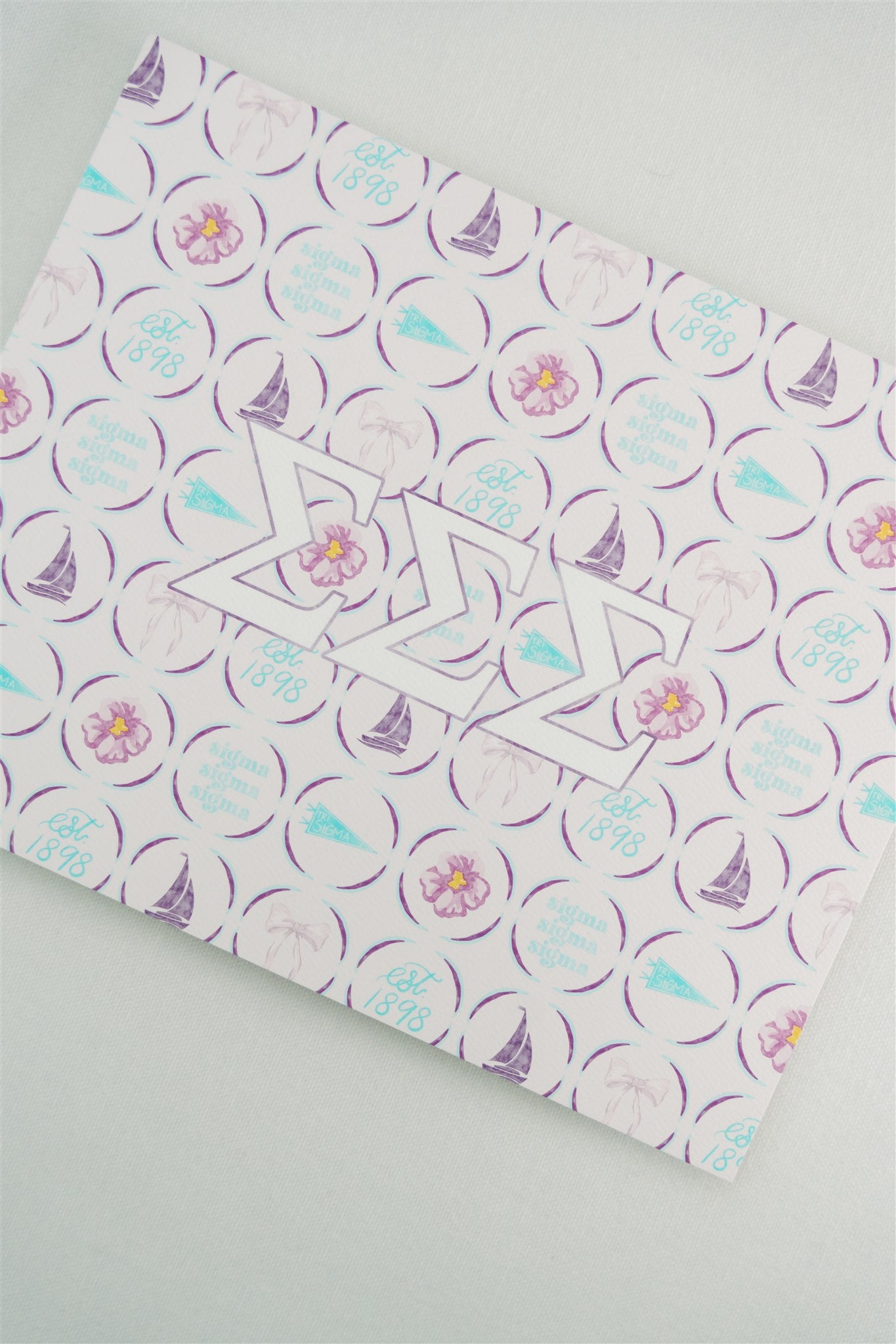 Art print with a decorative pattern and Tri Sigma Greek letters on a light gray background