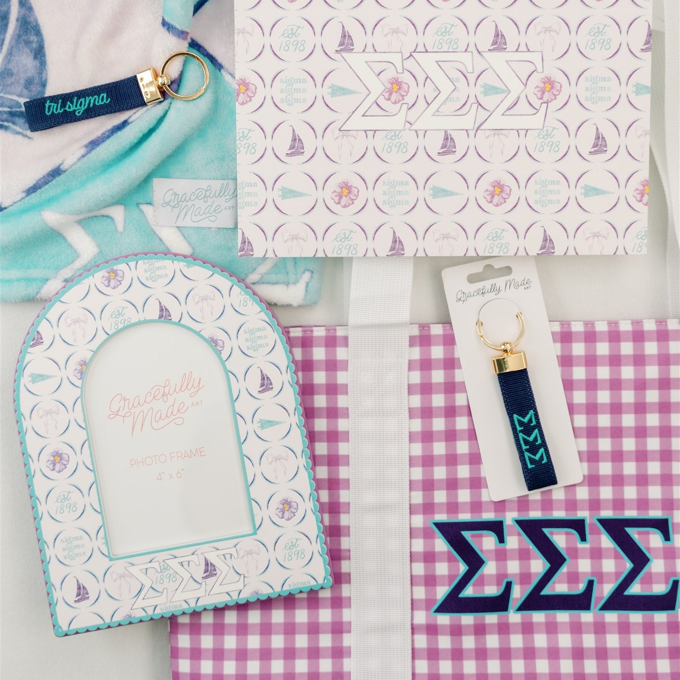 Collection of Tri Sigma decorative items including an art print, keychain, and checkered tote bag on a light gray background.