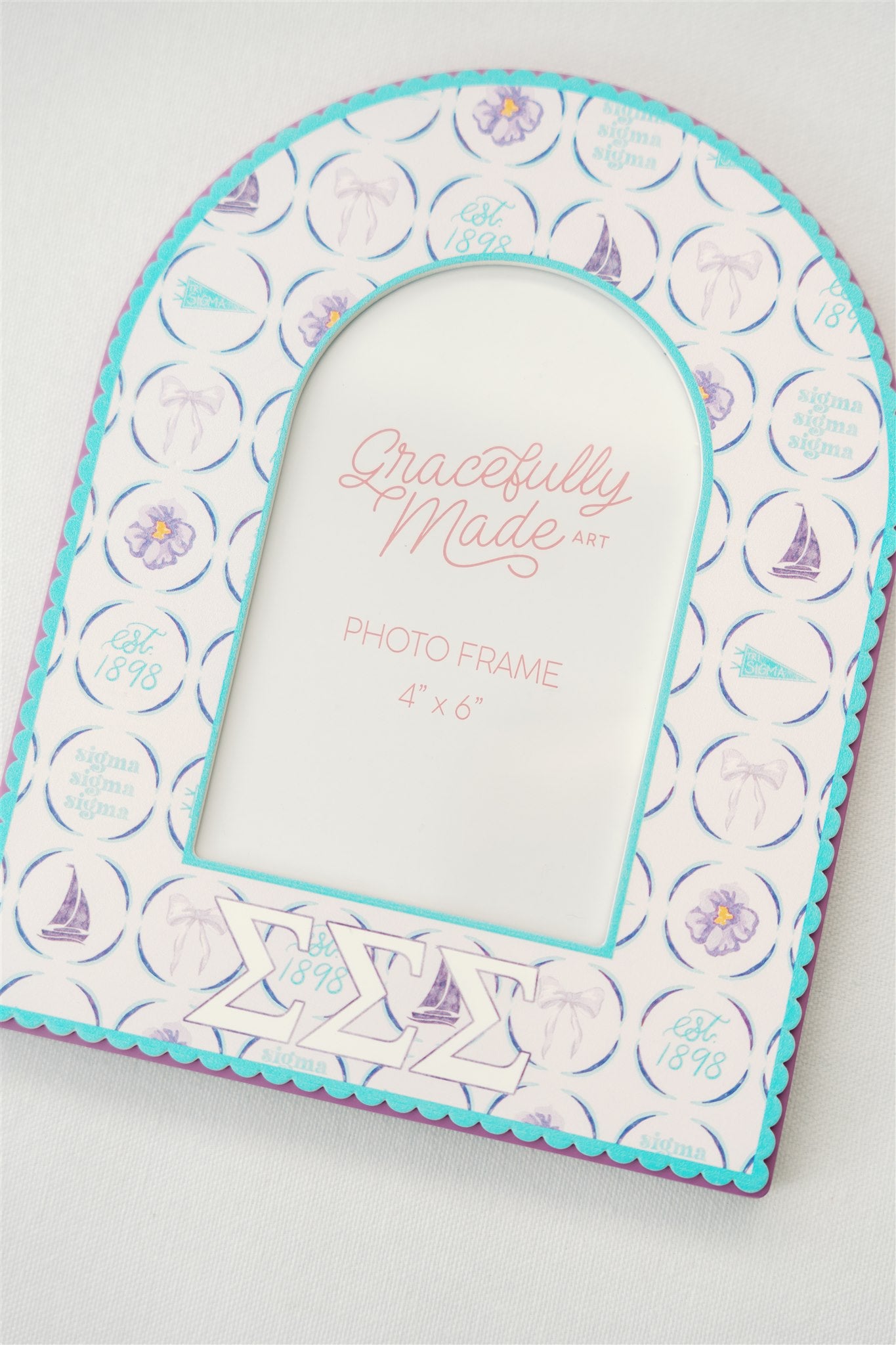 Decorative photo frame with Tri Sigma Greek letters and blue and purple pattern on a white background.