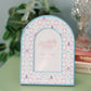 Decorative photo frame with Tri Sigma pattern and Greek letters on a green dresser.