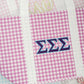 Close up of the Tri Sigma tote bag with a Greek letters, purple gingham pattern, and white handles.