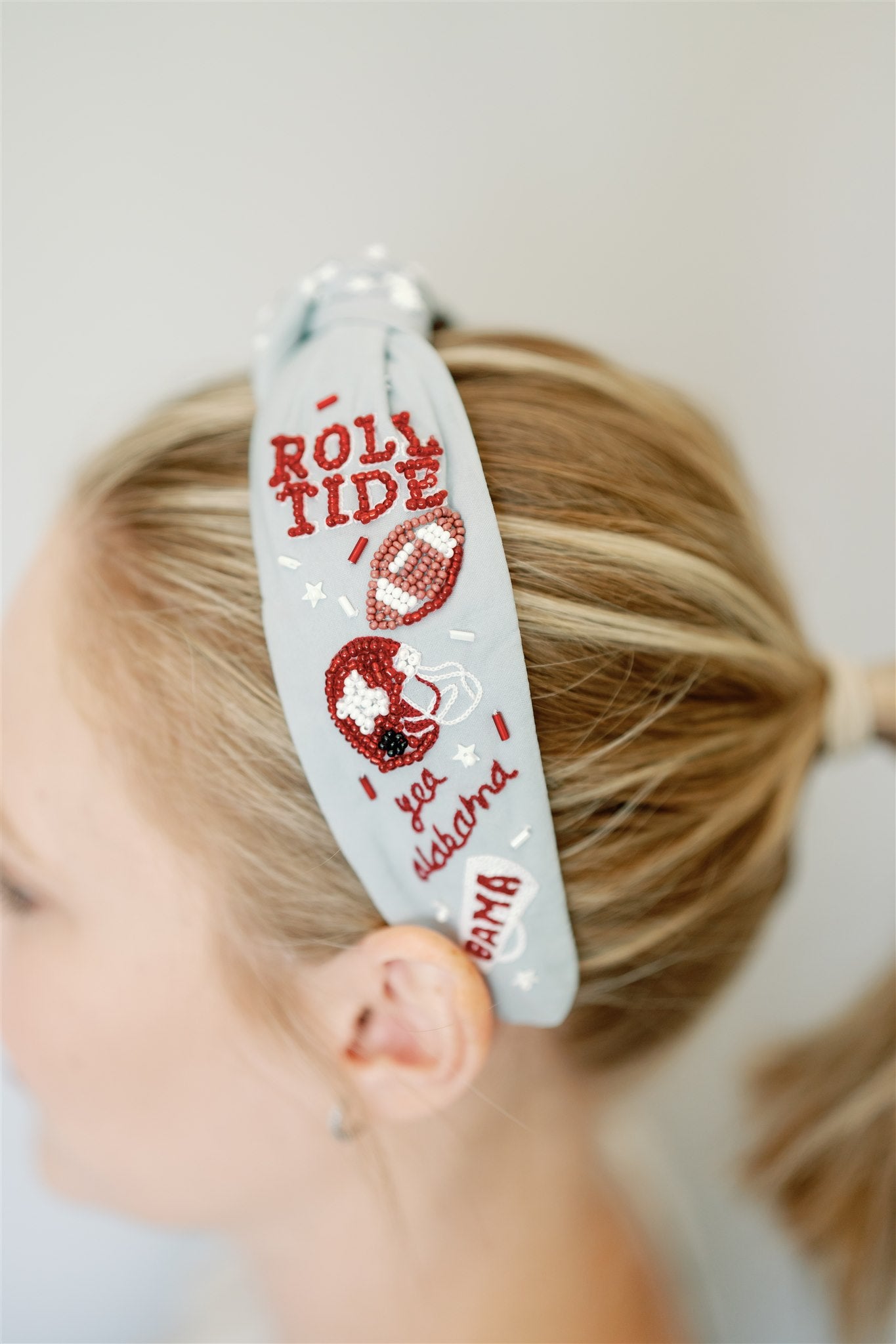 Light grey headband with red and white beaded University of Alabama symbols.