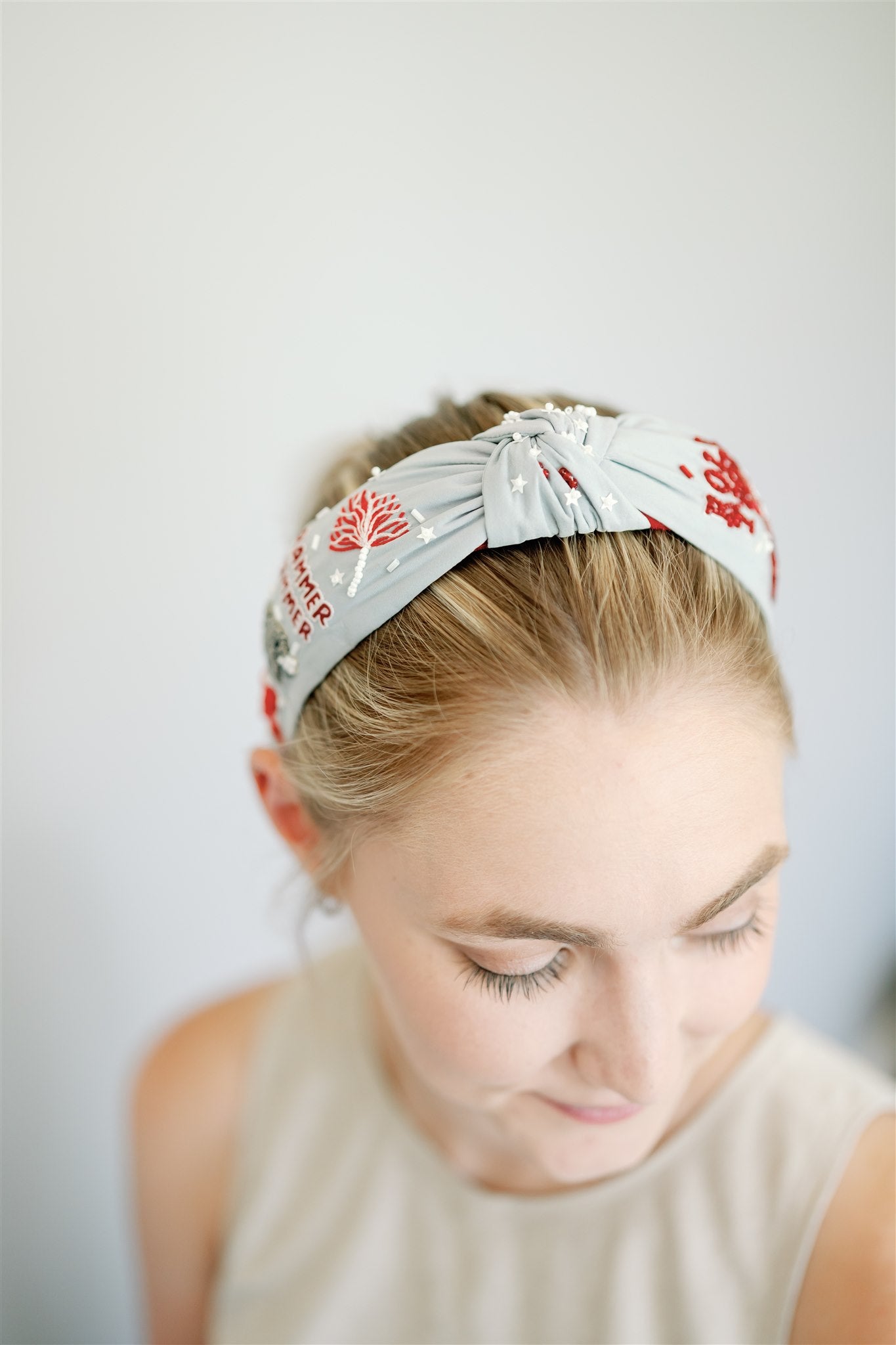 Light grey headband with red and white beaded University of Alabama symbols.