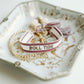 White and red woven bracelet with "Roll Tide" written down the middle.