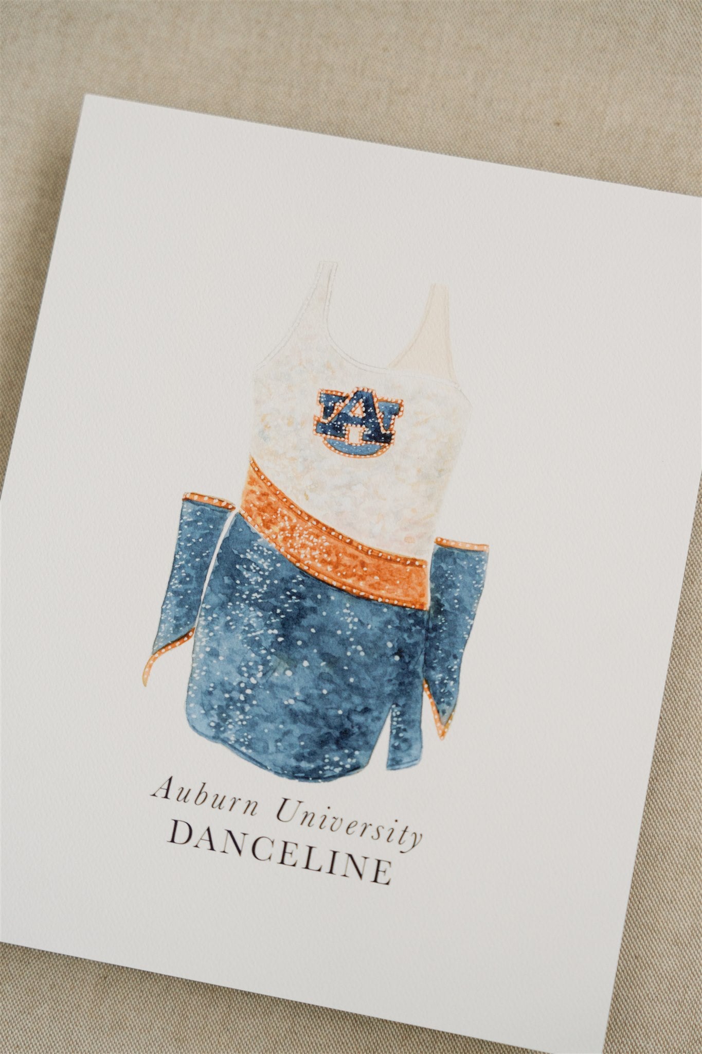 Watercolor art of the Auburn University Tiger Eyes Dance Uniform.