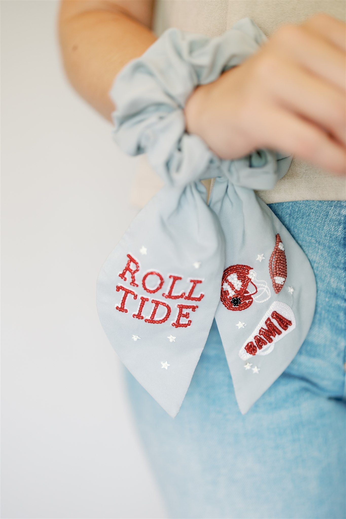 Light grey scrunchie with beaded University of Alabama symbols on the ribbons.