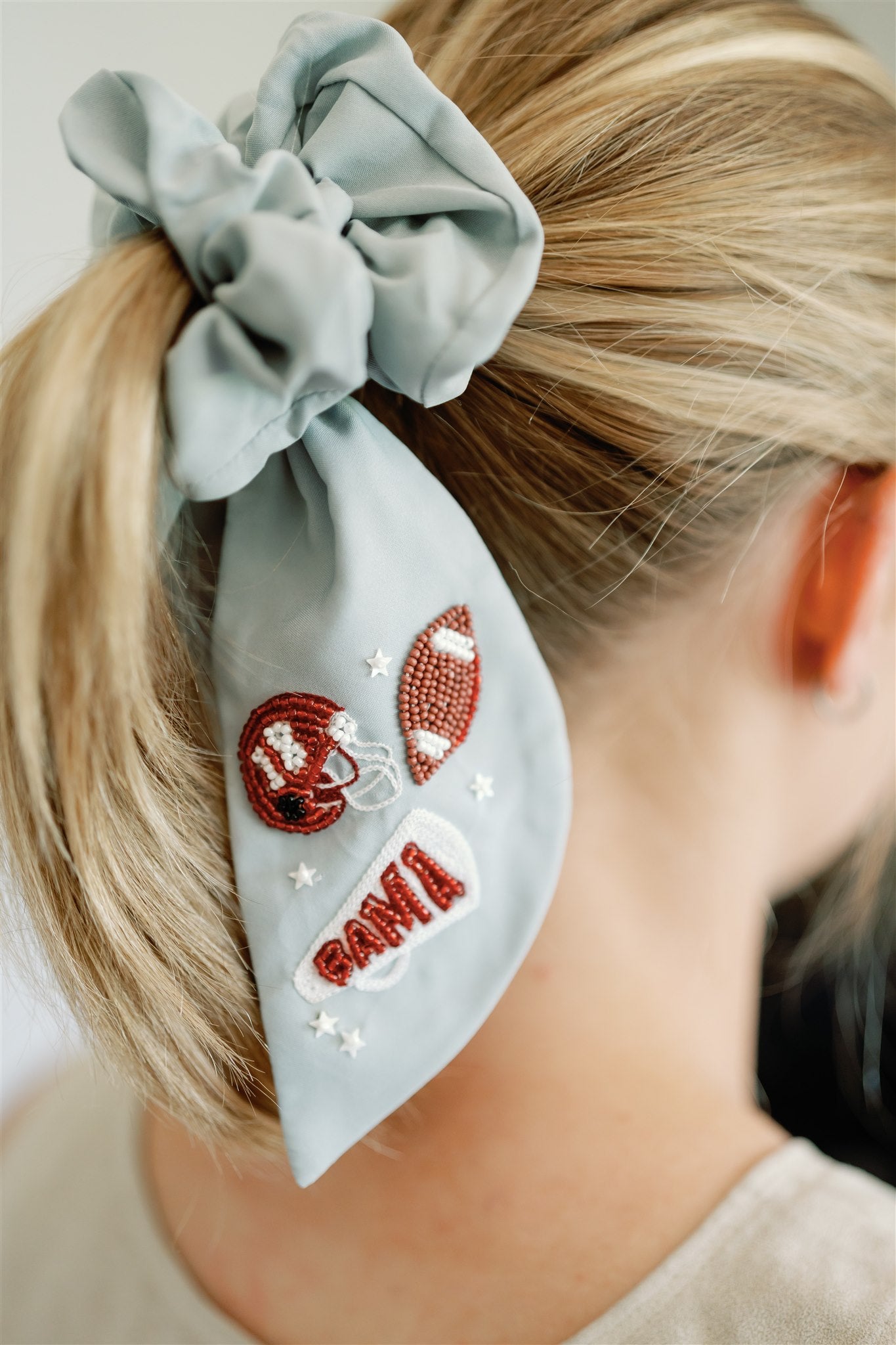 Light grey scrunchie with beaded University of Alabama symbols on the ribbons.
