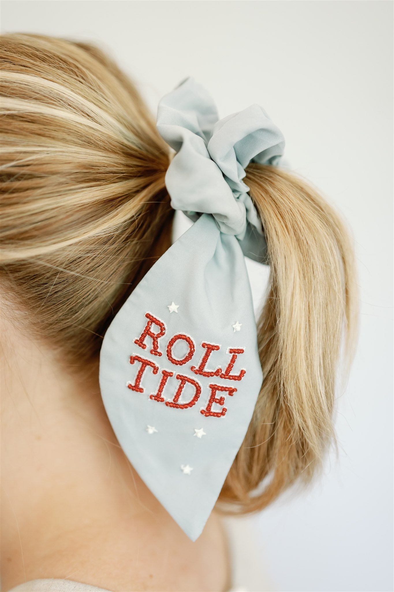 Light grey scrunchie with beaded University of Alabama symbols on the ribbons.