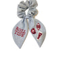 Light grey scrunchie with beaded University of Alabama symbols on the ribbons.
