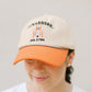 Person wearing a beige and orange baseball cap with 'Tennessee' text on a plain background