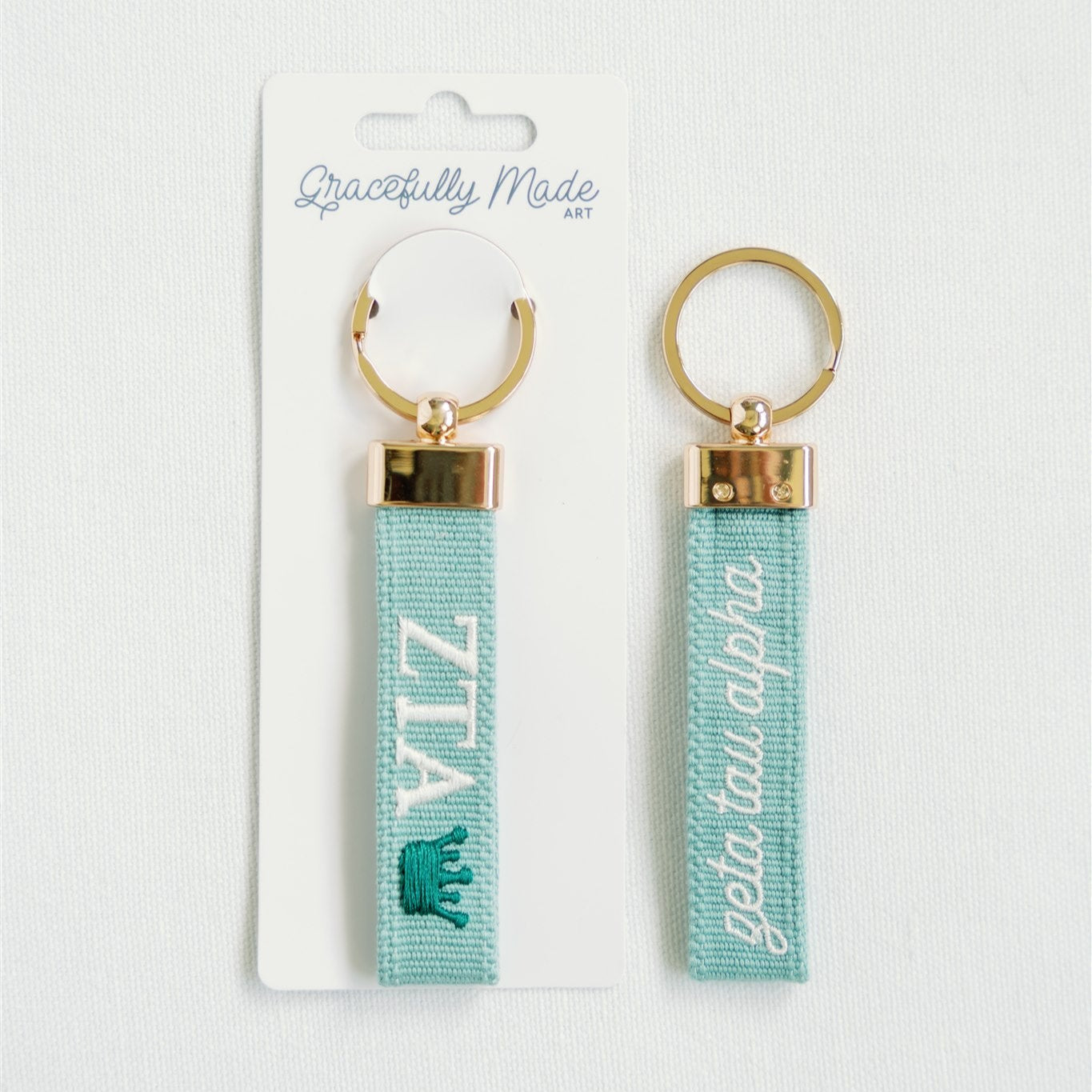 Front and back of Zeta keychain with Gracefully Made Art branded packaging. 