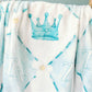 Blue checkered fleece blanket with a crown and ZTA Greek letters on it.