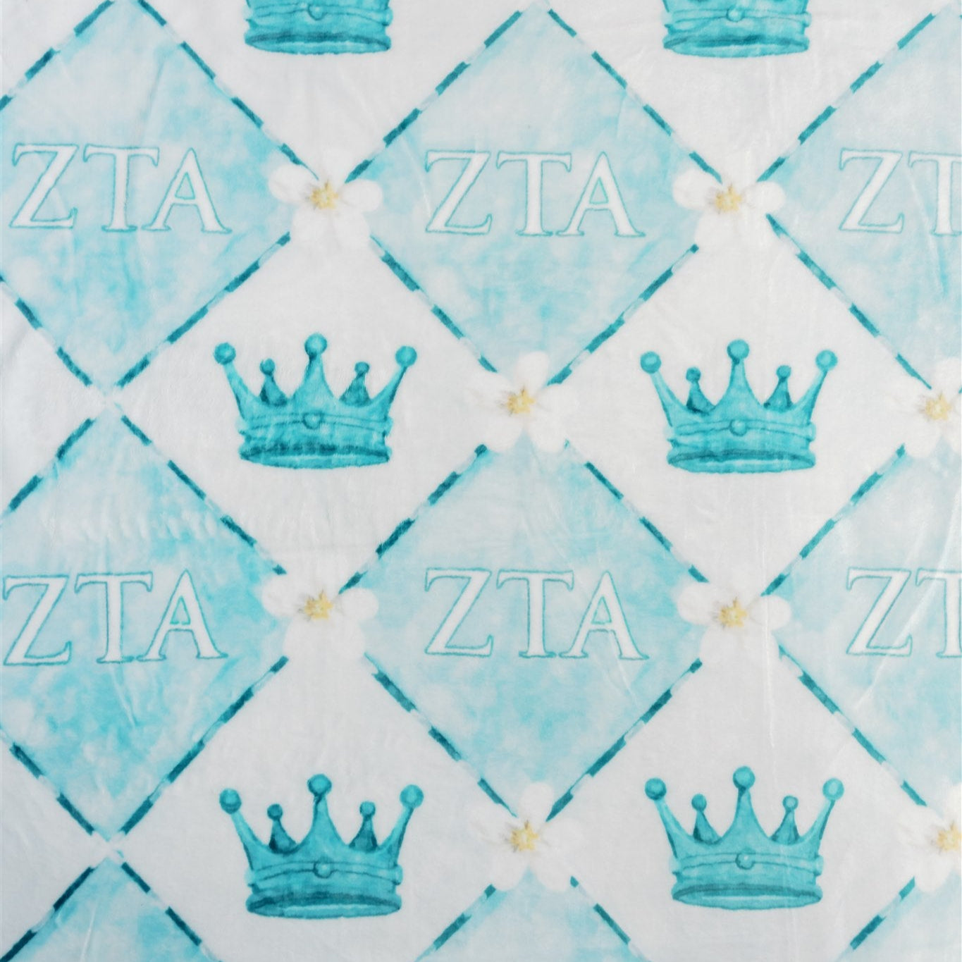 Patterned fabric with blue crowns and 'ZTA' Greek letters on a blue and white checkered background.