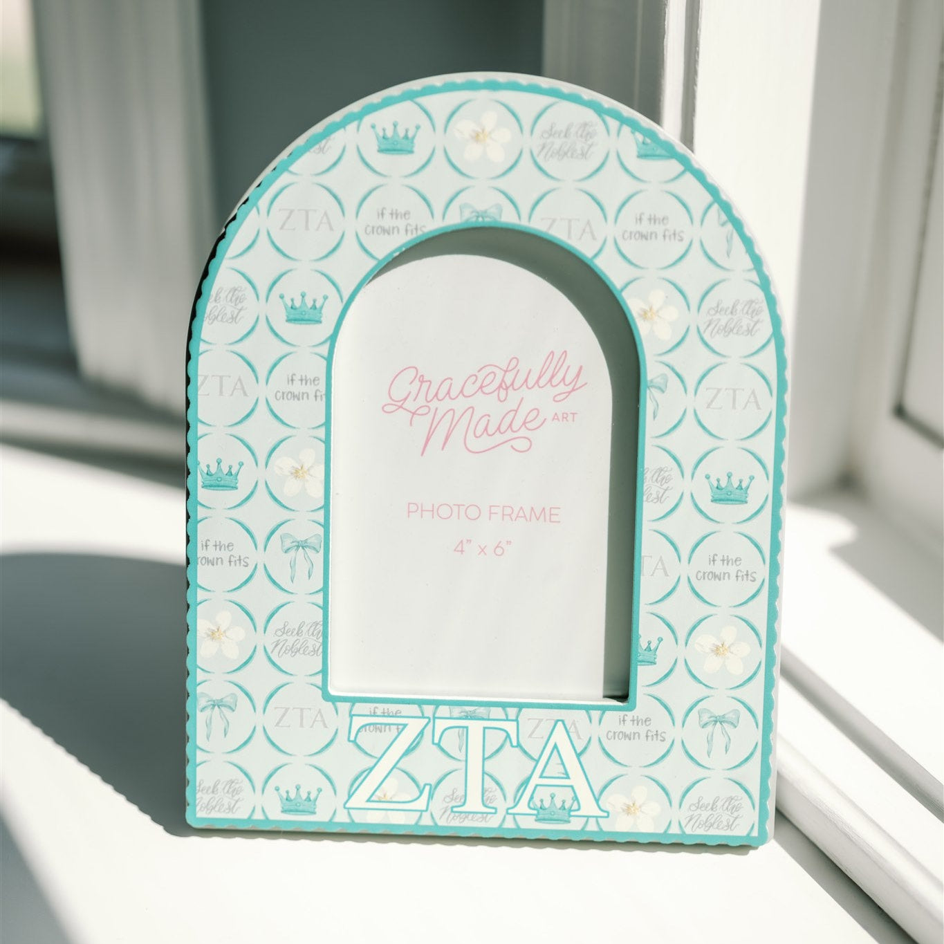 Decorative arch-shaped frame with 'Zeta Tau Alpha' Greek letters on a light background