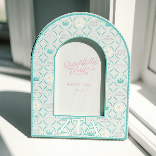 Decorative arch-shaped frame with 'Zeta Tau Alpha' Greek letters on a light background
